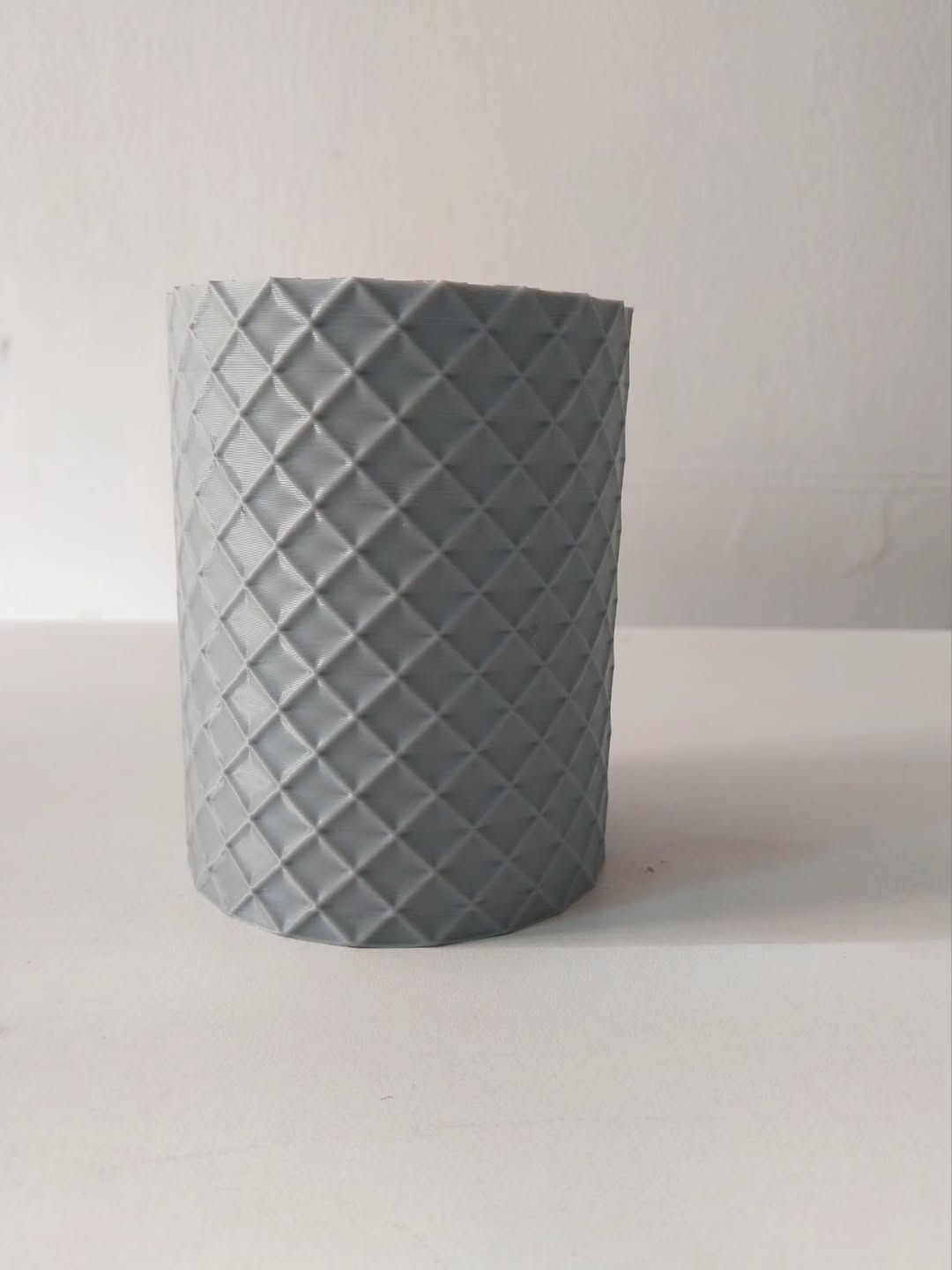Organizador gris impreso en 3D, con textura geométrica en rombos